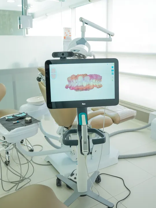 Consultorio con sillón odontológico y escáner intraoral junto al ventanal